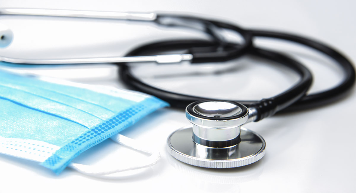 Closed up Stethoscope and Blue Surgical Mask on White Background